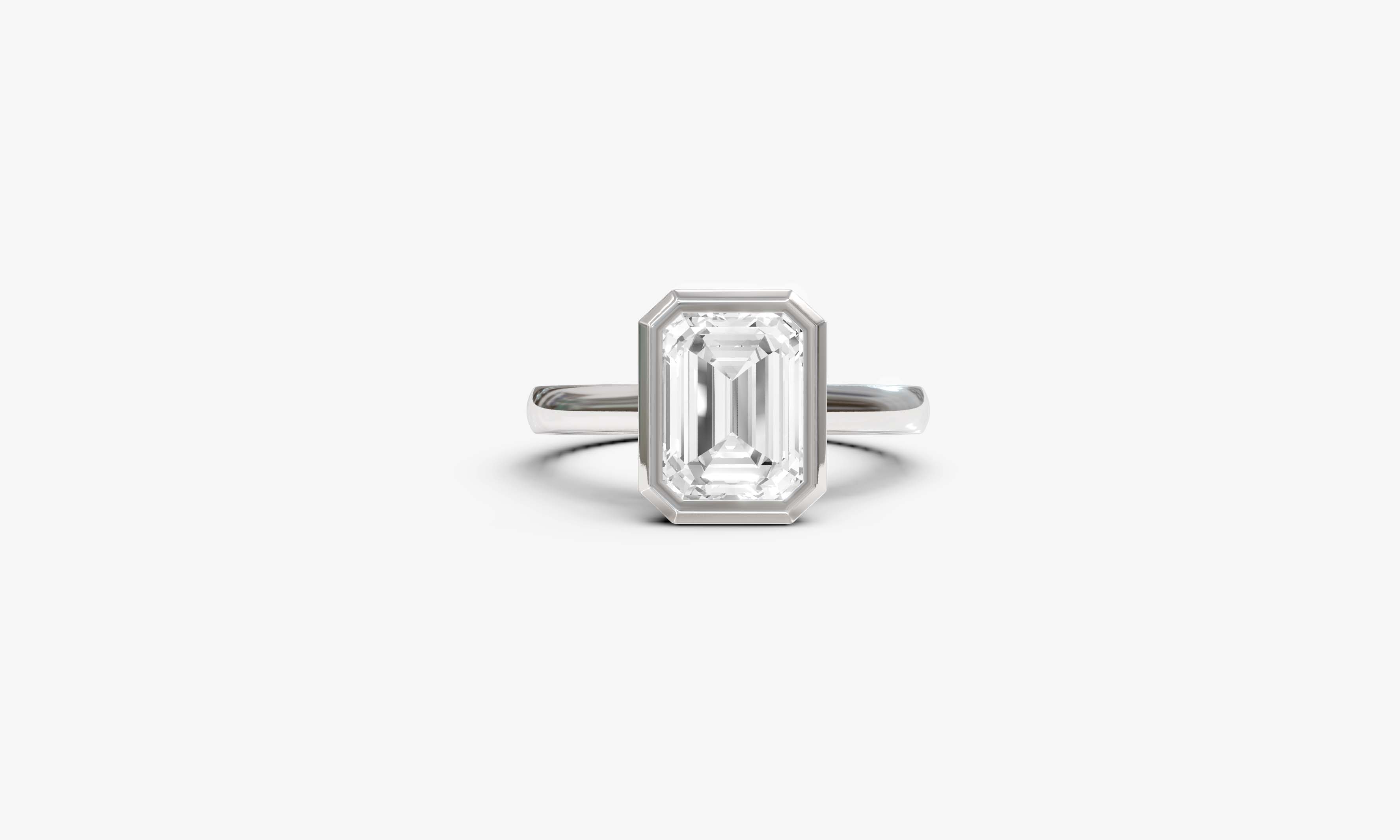 "It Girl" Bezel Emerald Cut Solitaire Ring in White Gold