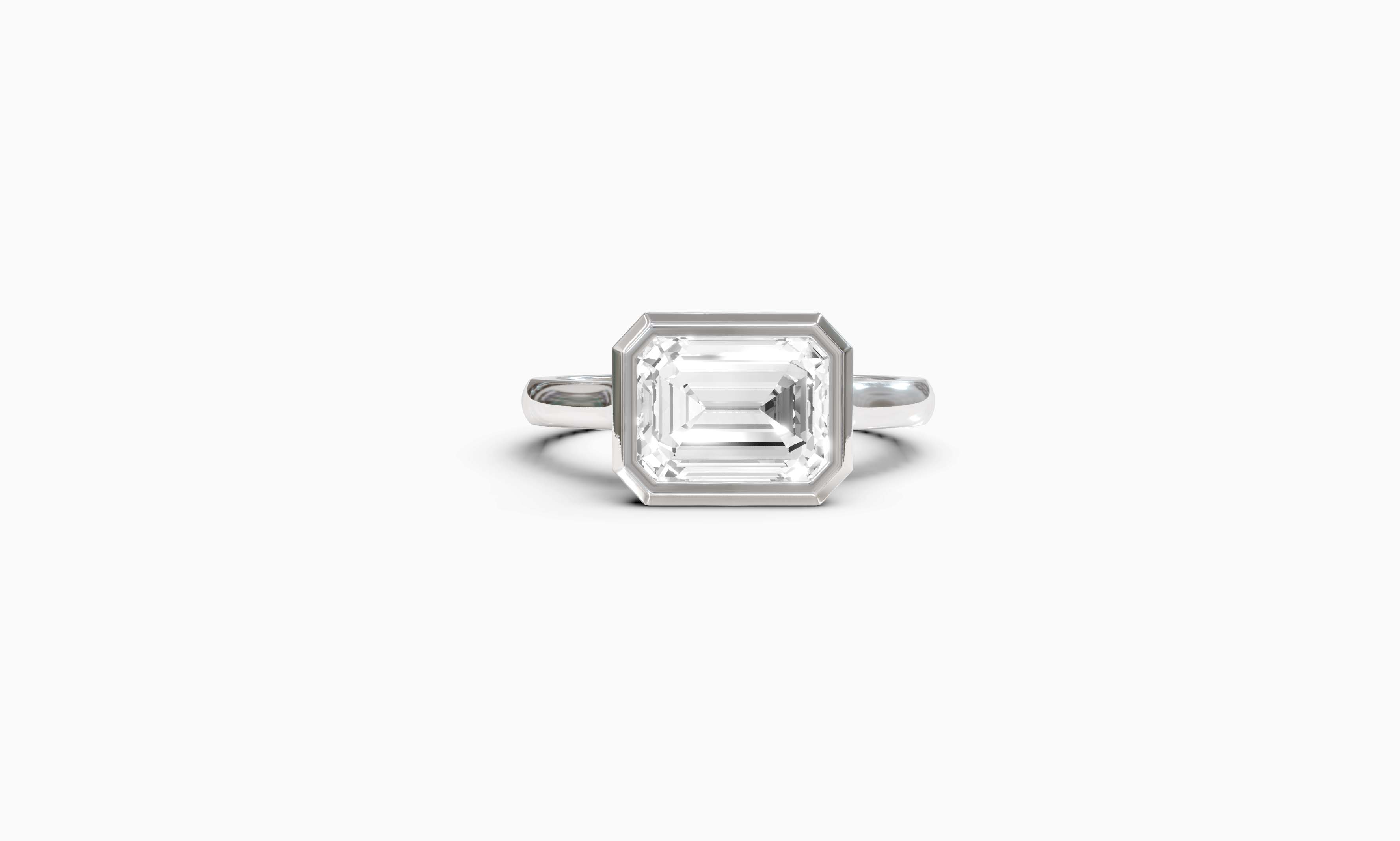 "It Girl" East-West Bezel Emerald Cut Solitaire Ring in White Gold